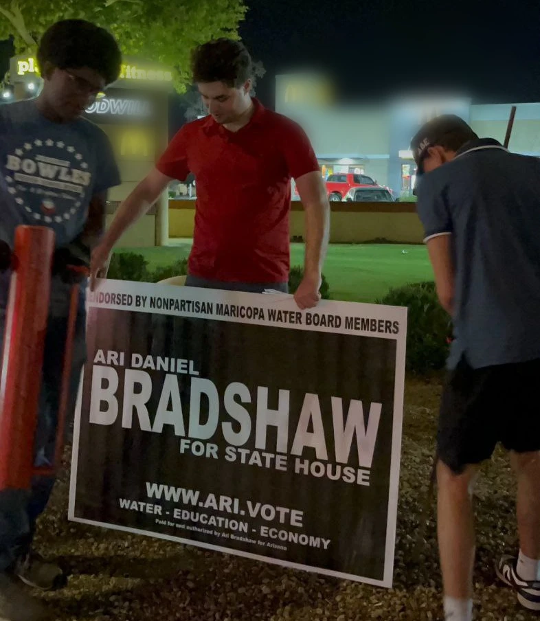 Ari Daniel Bradshaw, Nico Delgado, and Isaac Glover putting up a sign for Ari Daniel Bradshaw's 2024 campaign for State House